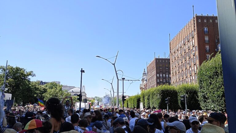 A large crowd filling a wide Budapest boulevard under a blue sky during Budapest Pride