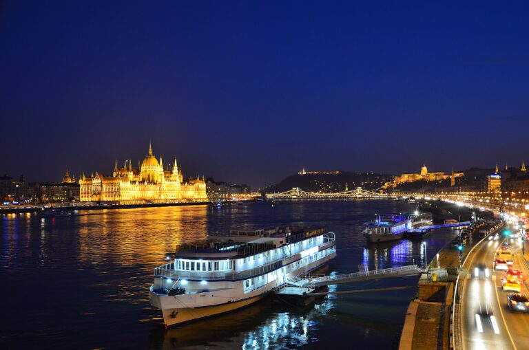 The Hungarian Parliament Building lit gold at night, seen across the Danube