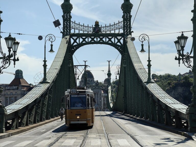 A yellow Budapest tram crossing the green Liberty Bridge.