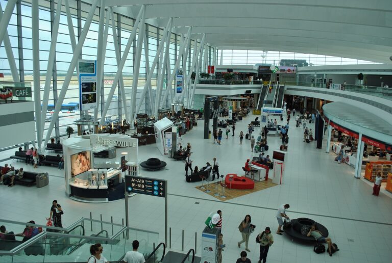 Passengers and shops inside the glass-roofed SkyCourt at Budapest Airport